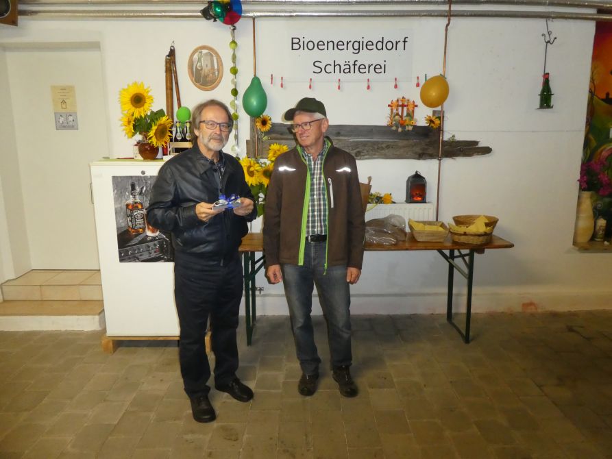 Vorsitzender StD a. D. Christian Nowotny bedankt sich bei Josef Haller mit einem Geschenk.