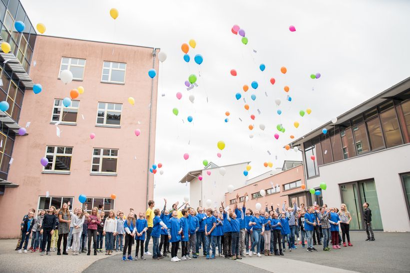 Fast 100 Luftballons mit persönlichen Wünschen der Schülerinnen und Schüler steigen in den Himmel.