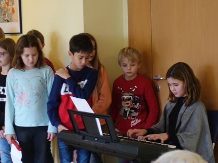 ... begleiten andere die Weihnachtslieder am Klavier.