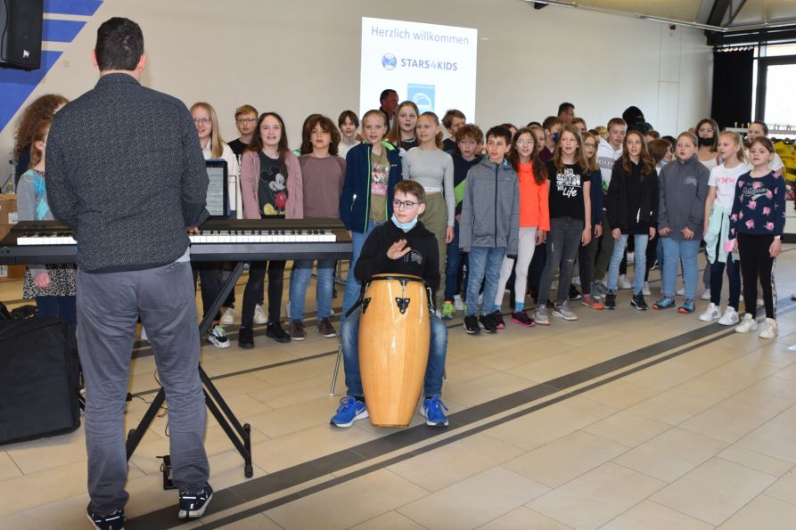 Die Chorklasse 5 begrüßte die Gäste von „Stars4Kids“ und die anwesenden Schülerinnen und Schüler musikalisch am Fraunhofer.