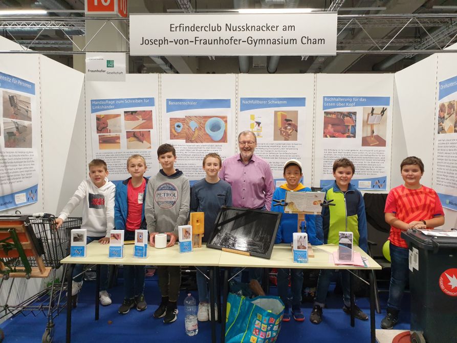 Die Schüler des Erfinderclubs Nussknacker vom Fraunhofer-Gymnasium zusammen mit ihrem Lehrer Robert Wagenbrenner an ihrem Stand auf der iENA – der Erfindermesse in Nürnberg.