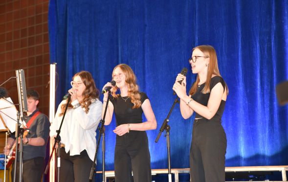 Die drei Frontsängerinnen der Schulband „Rising Stars“ in Action